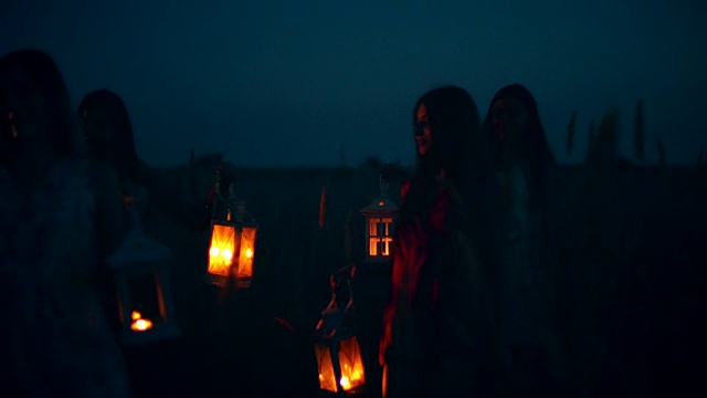 美丽的姑娘们在田野里散步——手里拿着蜡烛灯笼视频素材