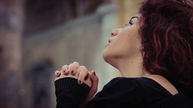 一个悲伤的女人在教堂祈祷:一个跪着祈祷的女人视频素材