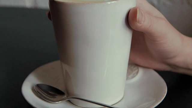 近距离拍摄咖啡杯在一个咖啡馆的女孩拿和喝视频素材