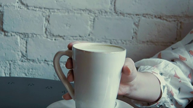 近距离拍摄咖啡杯在一个咖啡馆的女孩拿和喝视频素材