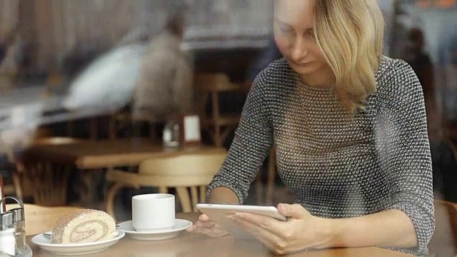 年轻漂亮的女人在咖啡厅里用药片喝茶视频素材
