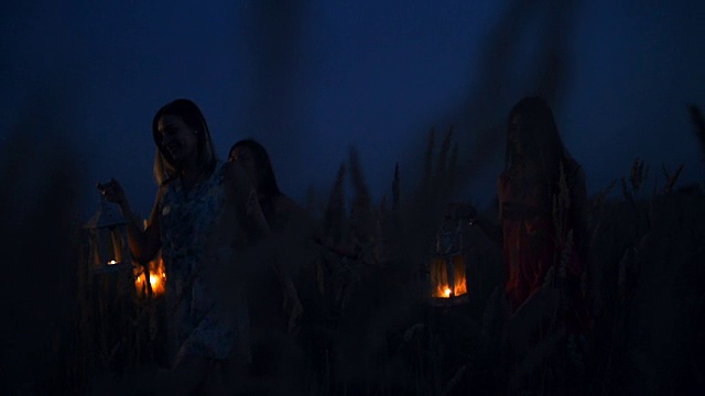 美丽的姑娘们在田野里散步——手里拿着蜡烛灯笼视频素材