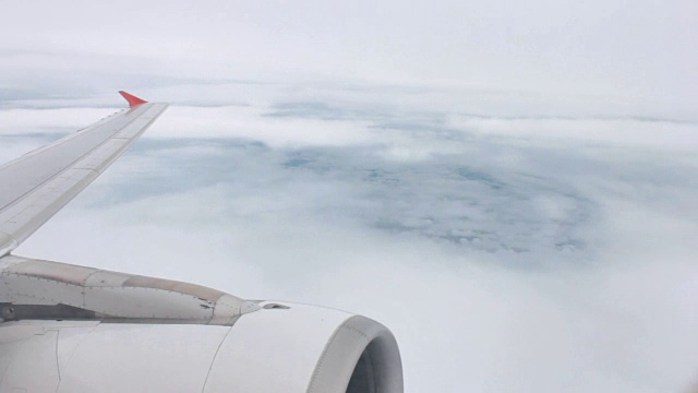鸟瞰图飞机机翼和发动机通过云和天空视频素材