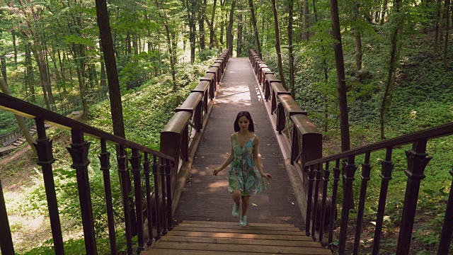 一个小女孩在公园里过了桥，上楼去了视频素材