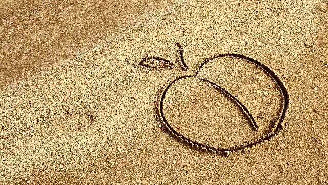 苹果在沙子上画画。视频下载