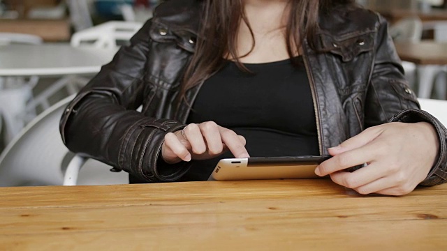特写的女孩手使用平板电脑上网坐在现代咖啡馆。FullHD视频素材