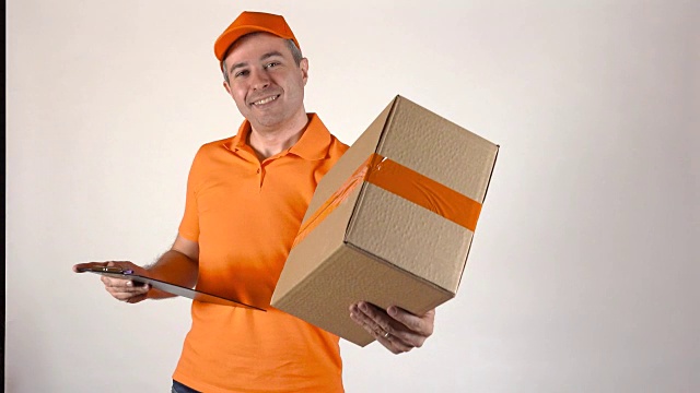 穿橙色制服的快递员正在送包裹。浅灰色背景，全高清工作室拍摄视频下载