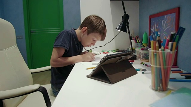 一个小男孩从平板电脑上复制了一幅画视频素材