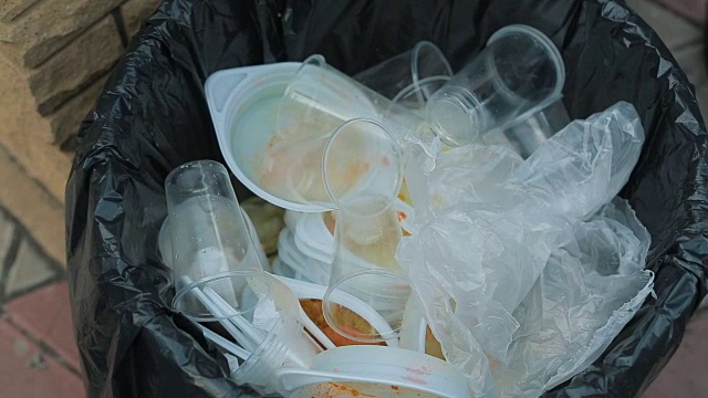 把塑料餐具放在垃圾桶里视频素材
