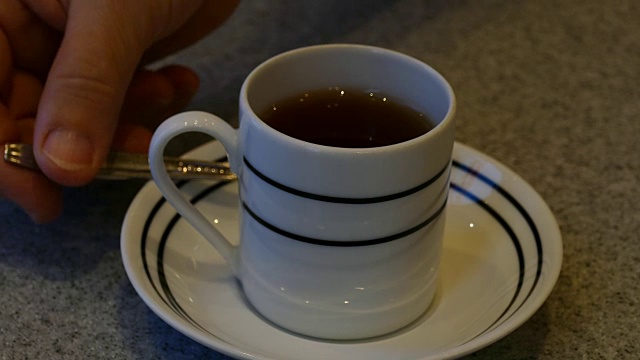 女人的手搅动着杯中的热茶视频素材
