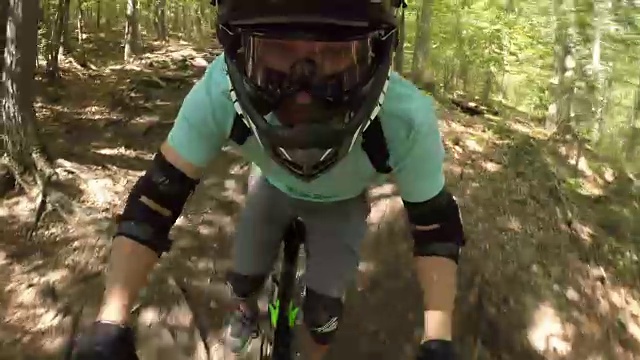 肖像特写:极限自行车骑下山的小径在浓密的绿色森林视频下载