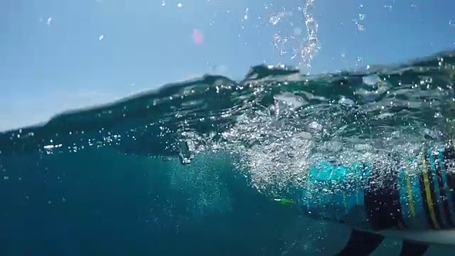 水下慢动作:微笑的冲浪者划桨在广阔的蓝色海洋冲浪视频素材