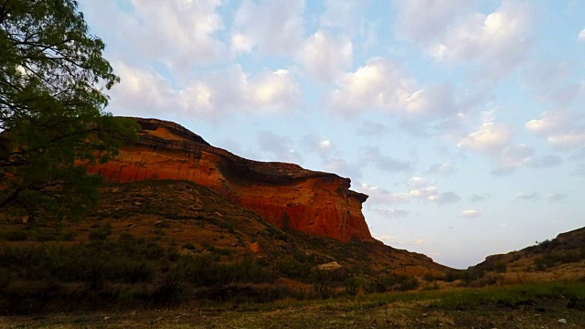 在雄伟的金门高地国家公园的岩石悬崖上的日落移动云，南非。时间流逝的视频。视频素材