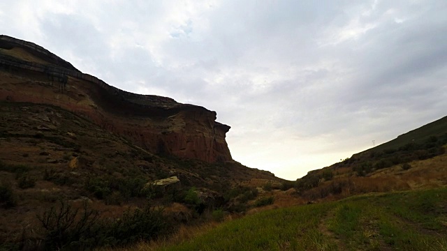 在雄伟的金门高地国家公园的岩石悬崖上的日落移动云，南非。时间流逝的视频。视频素材