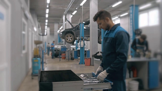 在现代服务站，机械师打开装有不同汽车修理工具的蓝色金属箱视频下载
