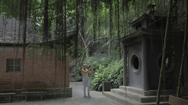 在越南，一个女人拿着便签拍摄宝塔视频素材