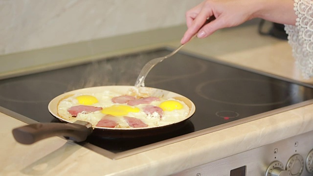 早餐用平底锅煎鸡蛋和火腿。烹饪视频下载