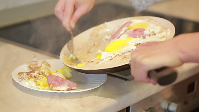 早餐用平底锅煎鸡蛋和火腿。烹饪视频下载