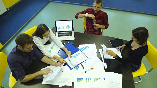 商务人士用笔记本电脑在木桌上写营销计划和分析图表视频下载