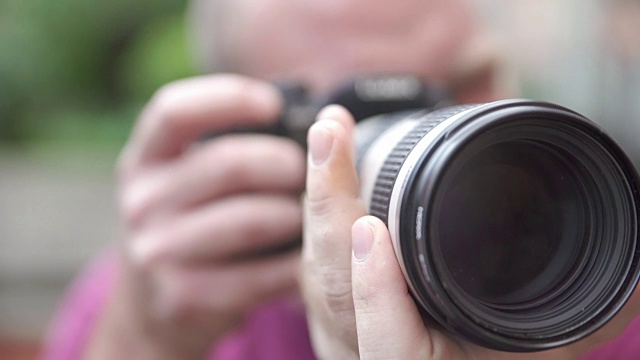 摄影师用照相机的一个大镜头给照相机定框视频下载