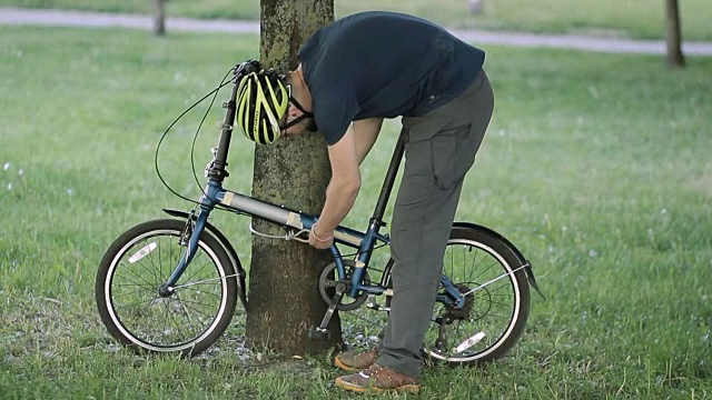 男人从树上解开自行车的锁视频下载