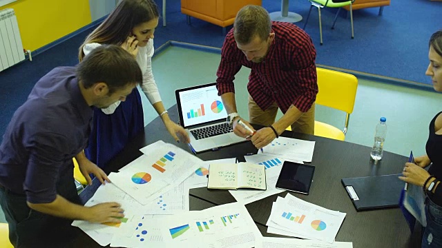 商务人士用笔记本电脑在木桌上写营销计划和分析图表视频素材