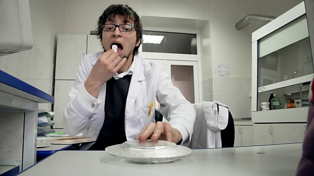 研究实验室里的年轻科学家在做日志记录，偷偷吃同事的糖果视频下载