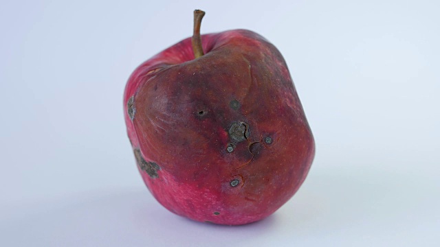 腐烂的苹果被孤立在白色的背景上视频下载