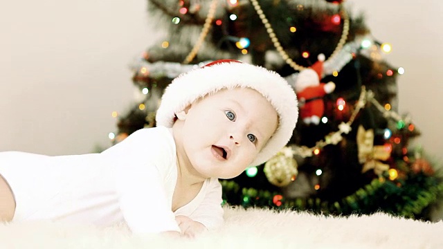 戴着圣诞帽的宝宝在新年的背景上视频下载