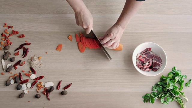 俯视图厨师手切胡萝卜在木板上，健康的食物概念视频素材