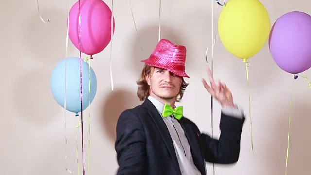 有魅力的男人戴着粉色的帽子，跳着有趣的舞蹈视频下载