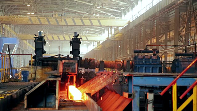 钢铁厂厂。工作机器移动着燃烧着的热坯视频素材