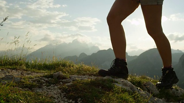特写:皮革山鞋和女性攀登陡峭的山顶的细节视频素材