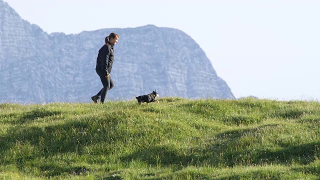 慢镜头:快乐的年轻女子和她的小宠物狗徒步冒险视频素材
