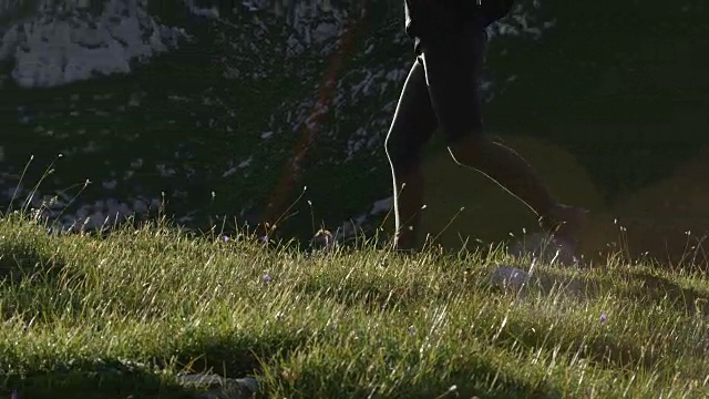近距离观察:强壮的年轻女子在迷人的阳光明媚的夏天在山上跑步视频素材