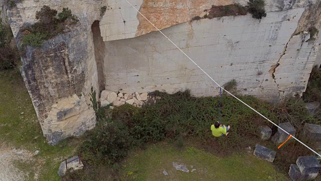 空中航拍:一名懒汉在高空保持平衡，下落并悬挂在安全绳索上视频素材