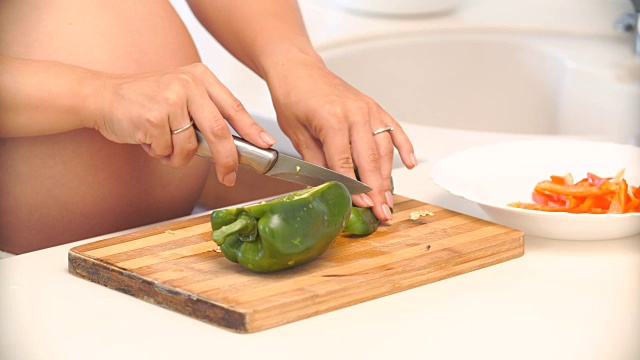 孕妇在厨房切辣椒。蔬菜沙拉视频素材