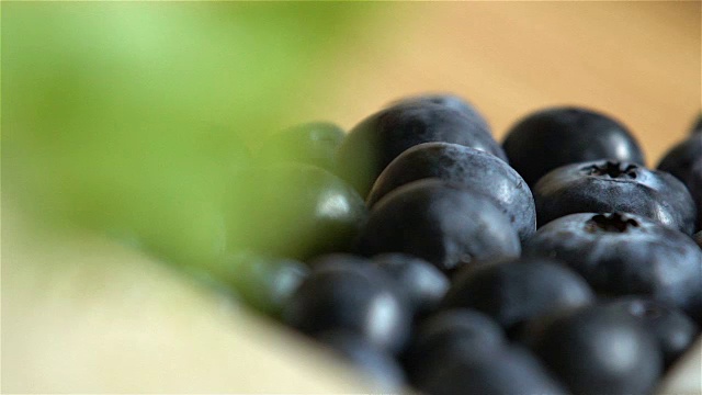 许多蓝莓在木头表面滚动。缓慢的运动。视频素材