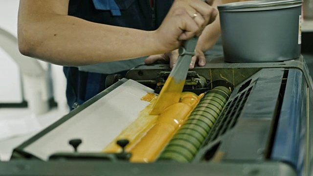 印刷工业工人使用黄色油漆油墨辊视频下载