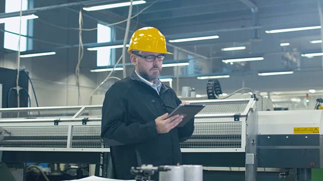 高级工程师正在一家工厂使用平板电脑。视频素材