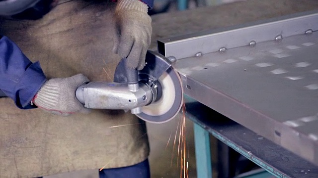 在金属加工厂使用工业磨床操作金属的工人视频素材
