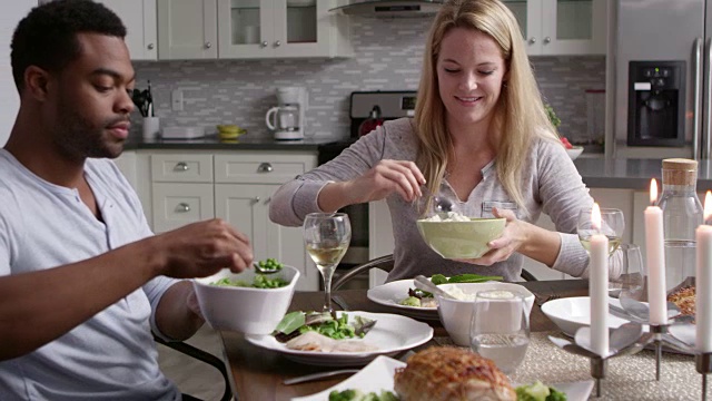 浪漫的混血夫妇在厨房用餐时祝酒，拍摄于R3D视频素材