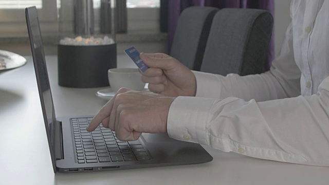 一名男子在笔记本电脑上购物，用信用卡支付视频素材
