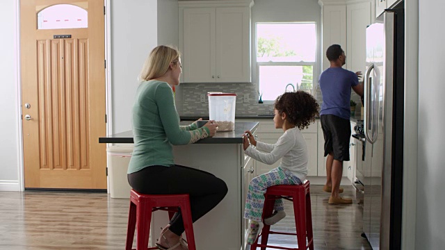 一对混血夫妇和女儿在厨房里聊天，全长，用R3D拍摄视频素材
