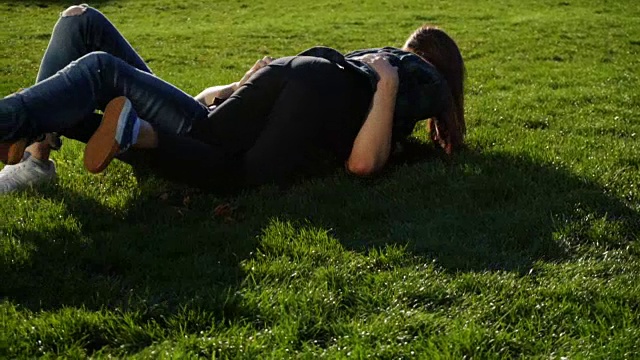 一对夫妇在草地上做夏季翻跟头，翻滚和翻跟头视频下载