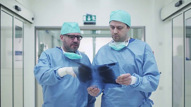 两位医生在医院里聊天。手里拿着平板电脑。视频素材