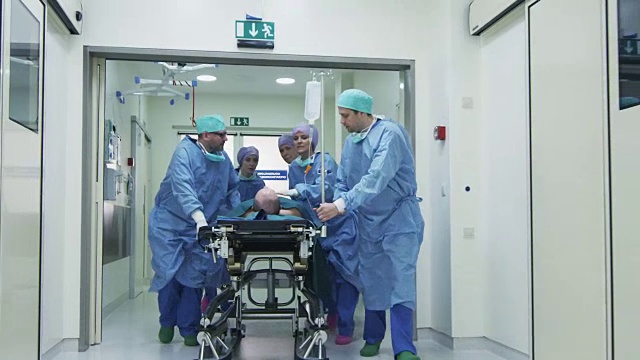 医院急救小组抬着病人担架穿过医院大厅视频素材