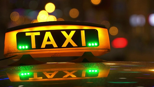 灯光标志的出租车在夜市特写模糊视频下载