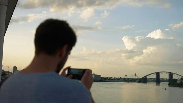 男人用智能手机数码相机拍摄令人惊叹的风景，美丽的夕阳光线创造背景与文本信息的复制空间视频素材