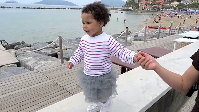 小女孩和妈妈走在高高的栏杆上视频下载